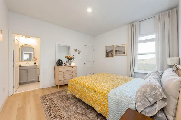 a bedroom with a white bed and dresser