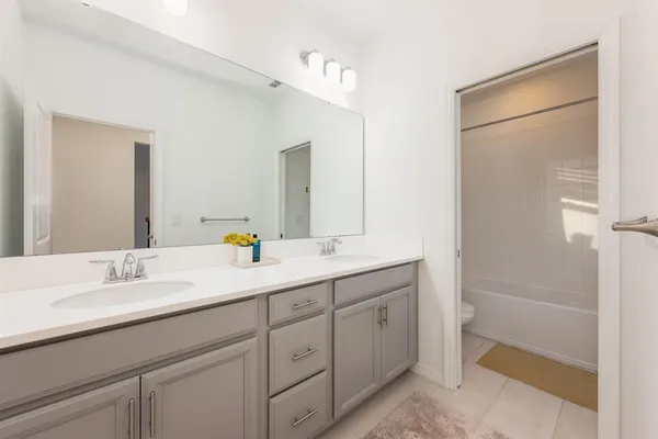 a bathroom with a double vanity sink and mirror
