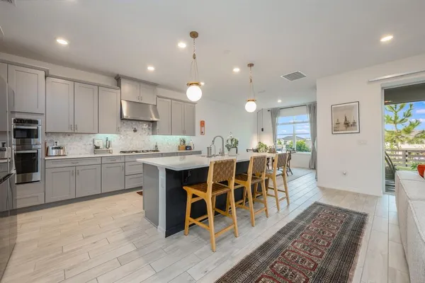 a kitchen with a dining table chairs sink and cabinets