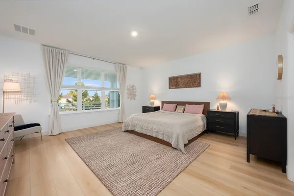 a spacious bedroom with a bed and a large window