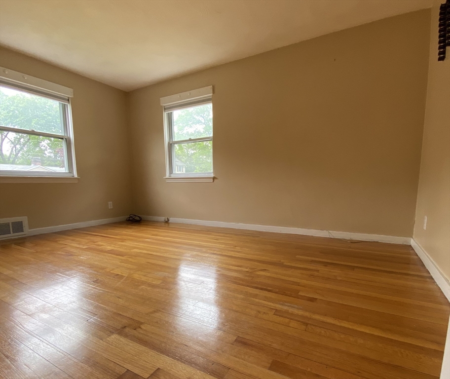 118 Spruce Road Norwood, MA 02062 - Photo 6 of 39 a view of an empty room with wooden floor and a window
