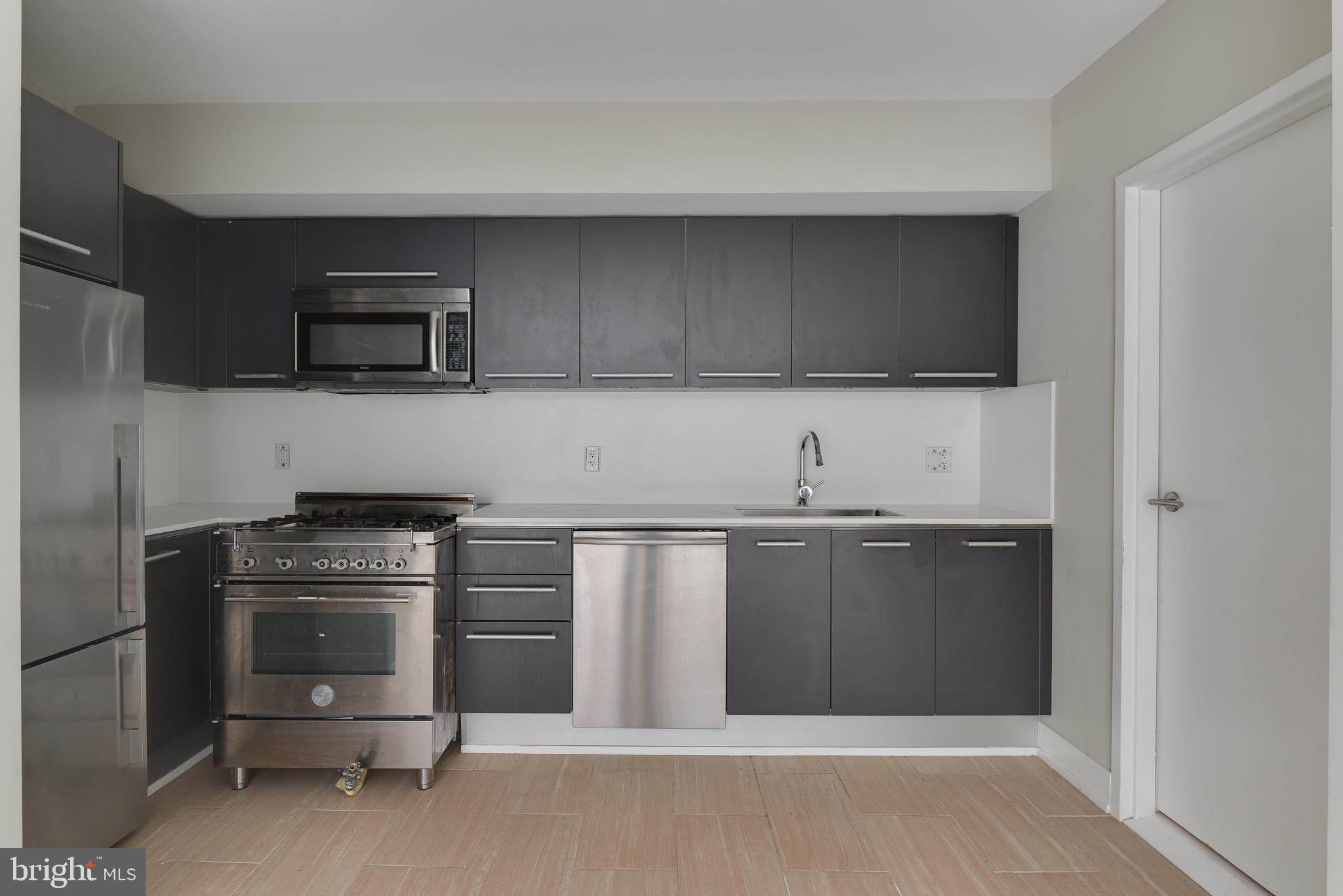 2250 11th Street Northwest, Unit 108 Washington, DC 20001 - Photo 12 of 26 a kitchen with granite countertop a stove and a microwave