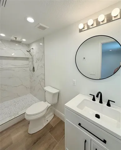 a bathroom with a sink a toilet and shower