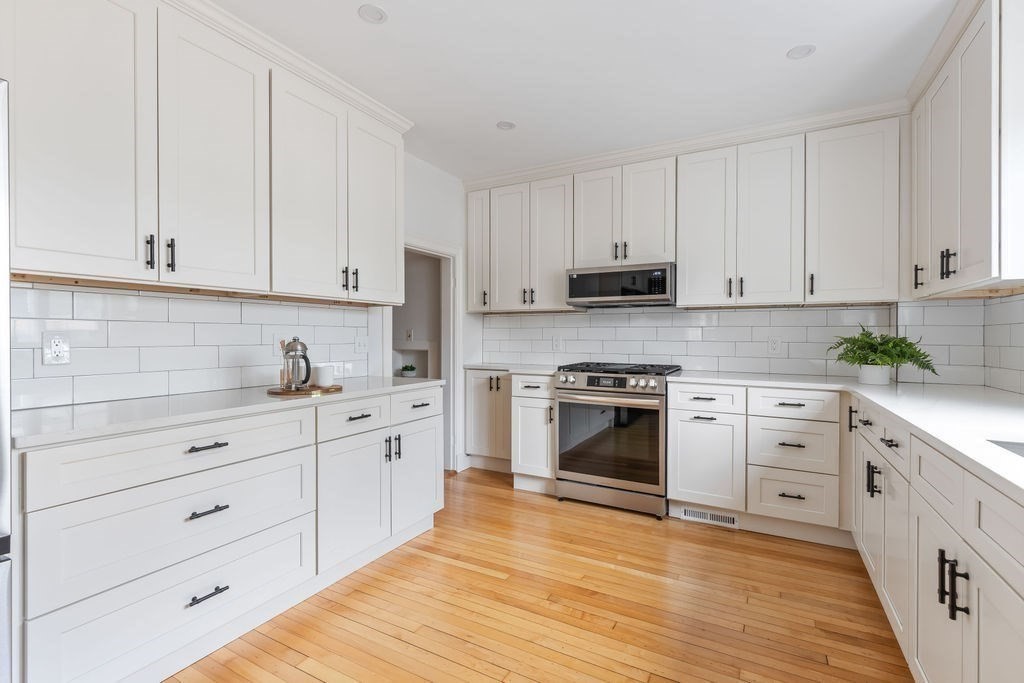 311 Clark Road Brookline, MA 02445 - Photo 9 of 26 a kitchen with granite countertop white cabinets and white appliances