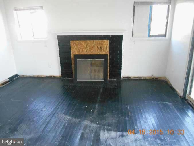 2506 Kingsway Road Fort Washington, MD 20744 - Photo 4 of 8 an empty room with wooden floor a fireplace and a window