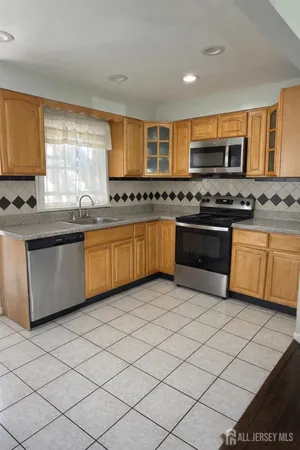a kitchen with stainless steel appliances granite countertop a stove sink and cabinets