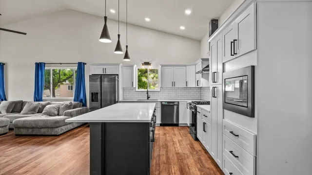 a large kitchen with stainless steel appliances kitchen island a large counter top and a sink