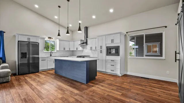 a large kitchen with stainless steel appliances granite countertop a stove and a sink