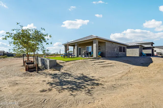 an aerial view of a house with a yard and ocean