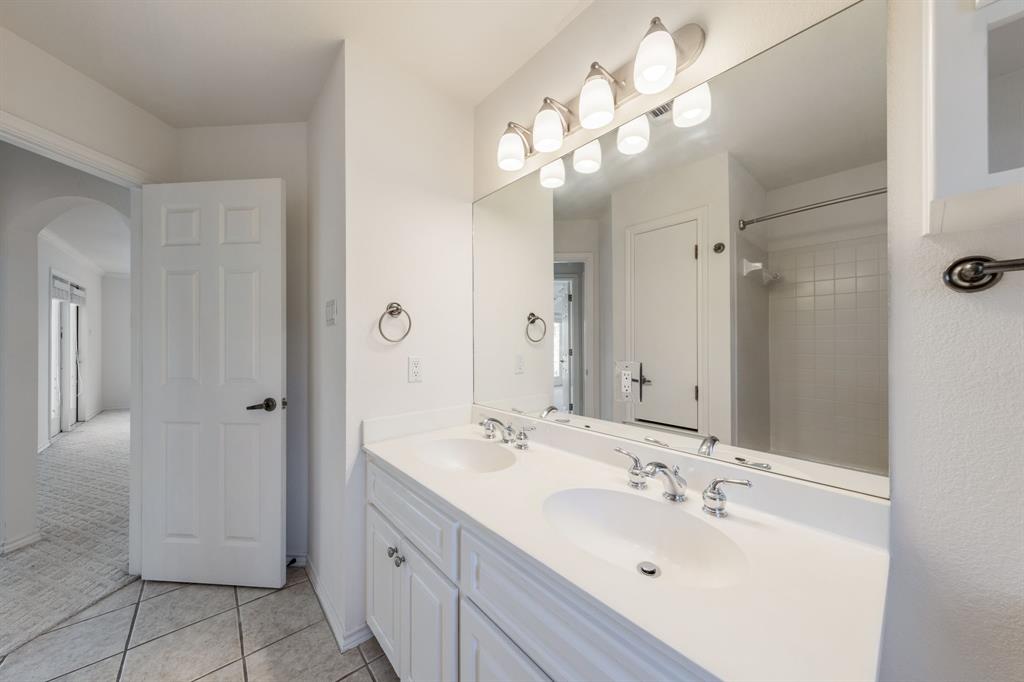 1704 Randolph Ridge Trail Austin, TX 78746 - Photo 19 of 23 Full bath featuring double vanity, tile patterned flooring, walk in shower, and a sink