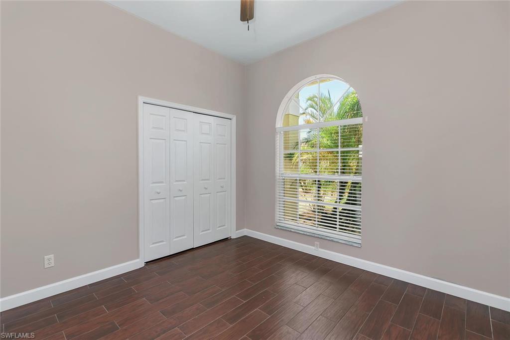 2389 Piccadilly Circus Naples, FL 34112 - Photo 11 of 21 an empty room with wooden floor fan and windows
