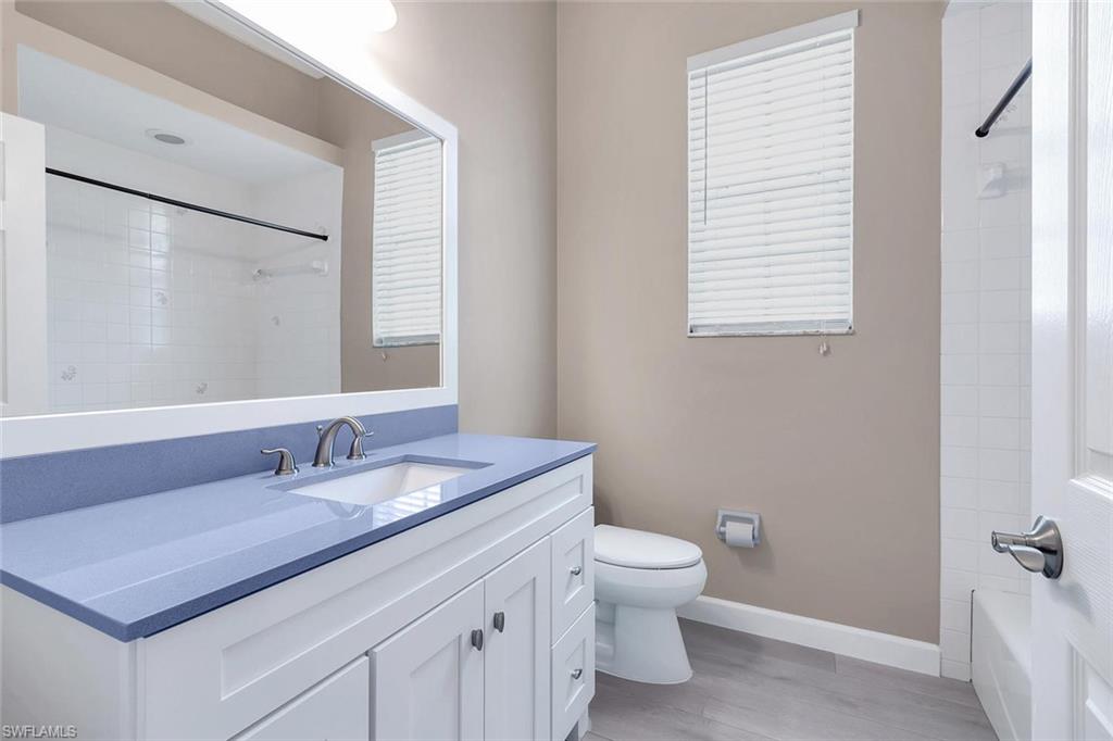 2389 Piccadilly Circus Naples, FL 34112 - Photo 12 of 21 a bathroom with a granite countertop sink a toilet and a mirror