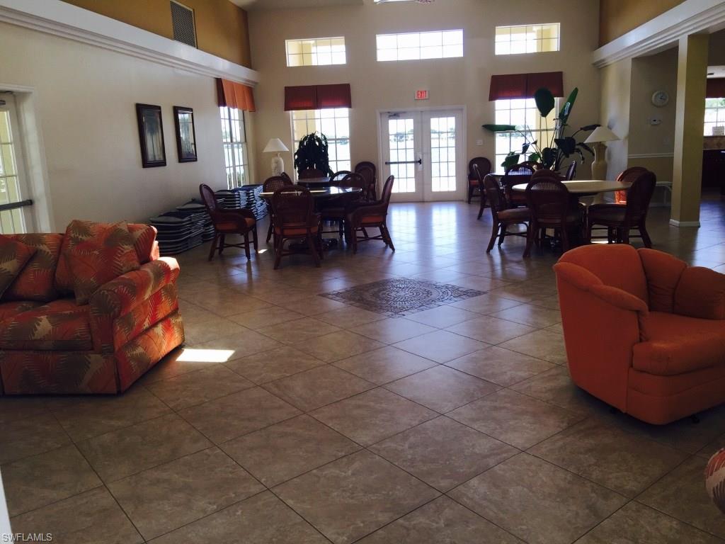 2389 Piccadilly Circus Naples, FL 34112 - Photo 17 of 21 a living room with furniture a dining table and a fireplace