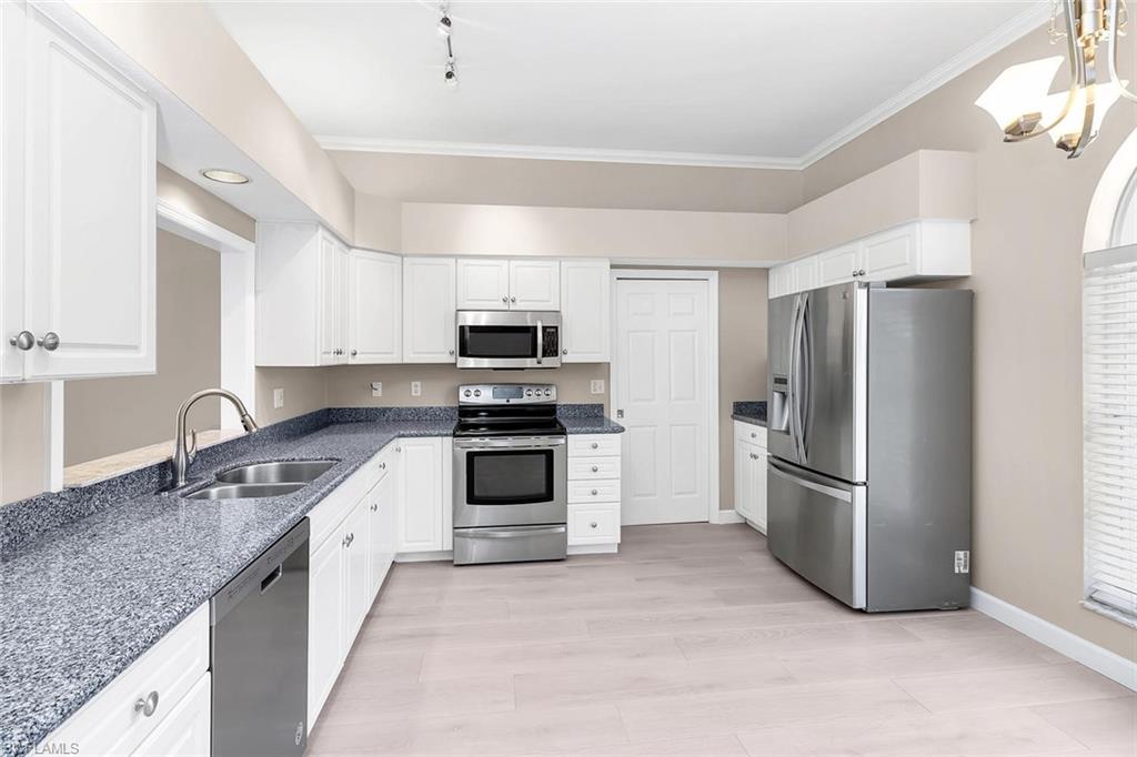 2389 Piccadilly Circus Naples, FL 34112 - Photo 4 of 21 a kitchen with stainless steel appliances granite countertop a refrigerator a stove a sink and a microwave