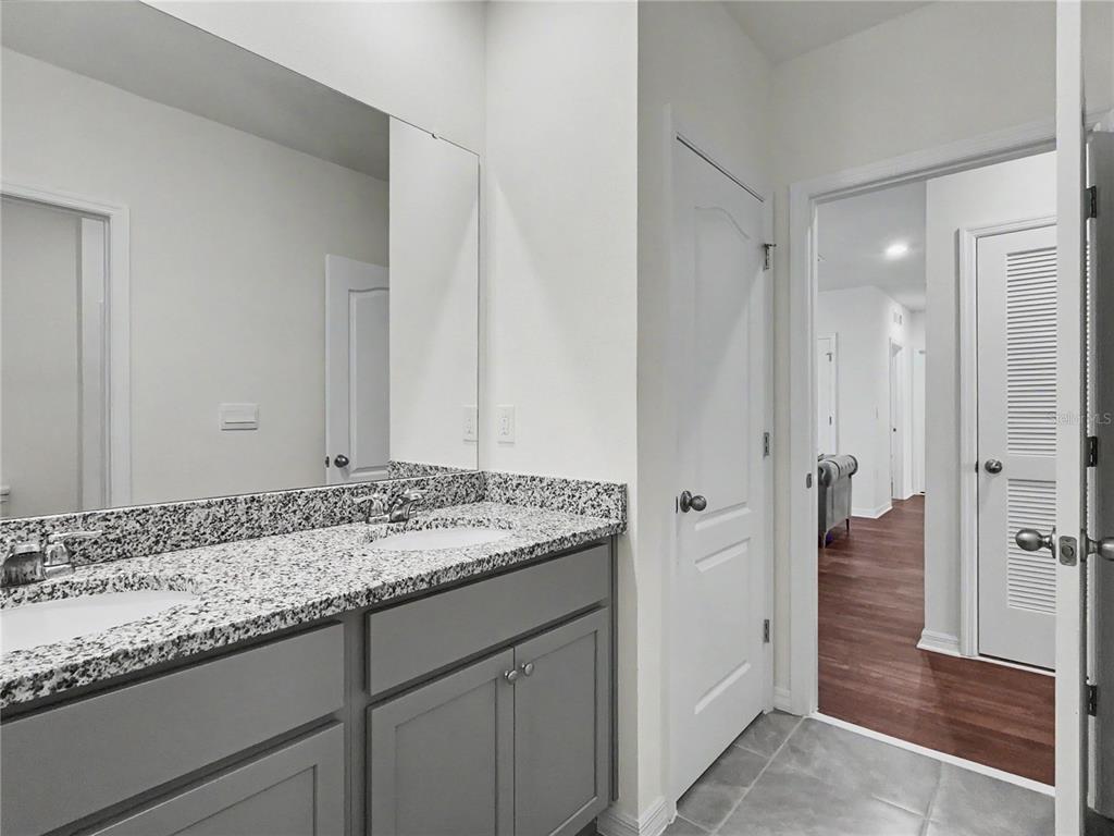 2085 Doe Run Drive Davenport, FL 33837 - Photo 40 of 44 a bathroom with a granite countertop sink and a mirror