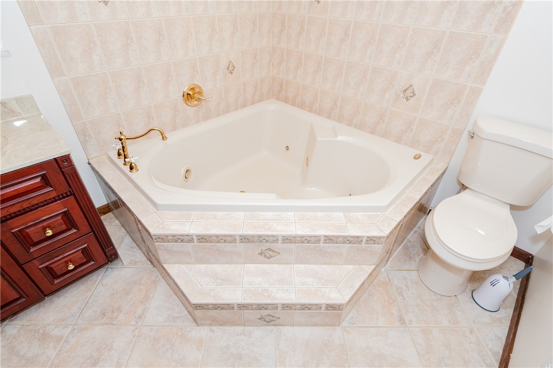 6750 Little Twin Road Germantown, OH 45327 - Photo 23 of 88 This bathroom features a corner tub with tiled surround and elegant gold fixtures.