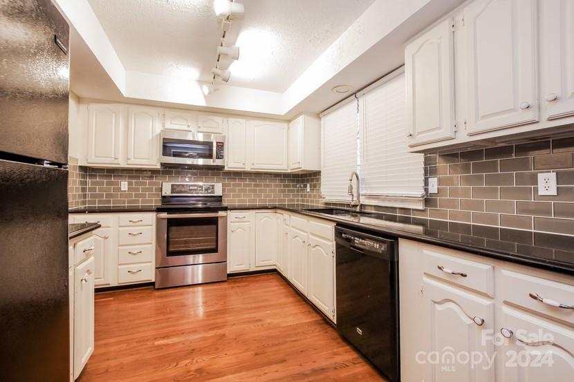 9325 Raintree Lane Charlotte, NC 28277 - Photo 5 of 15 a kitchen with kitchen island granite countertop a sink cabinets and stainless steel appliances