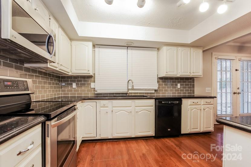 9325 Raintree Lane Charlotte, NC 28277 - Photo 6 of 15 a kitchen with granite countertop wooden cabinets and a stove