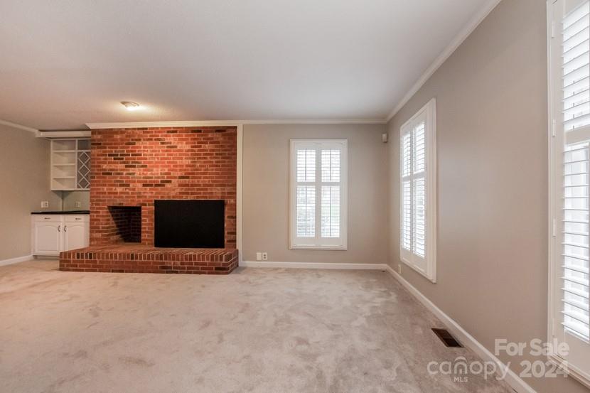 9325 Raintree Lane Charlotte, NC 28277 - Photo 9 of 15 an empty room with a fireplace and large windows