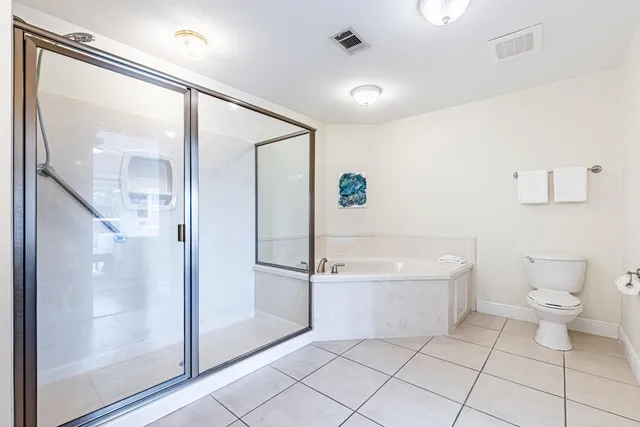 a spacious bathroom with a tub sink and mirror