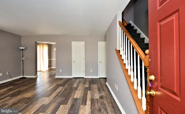 a view of a hallway with wooden floor and staircase
