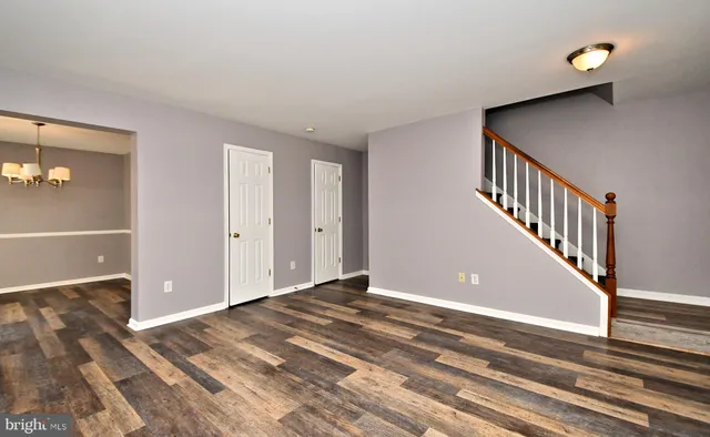 a view of a livingroom with wooden floor and staircase