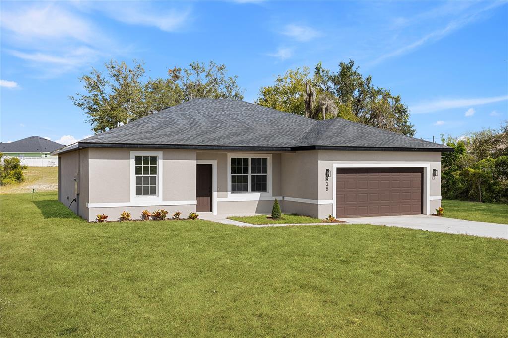 925 Desmoines Way Poinciana, FL 34759 - Photo 1 of 40 a front view of house with yard and trees in the background