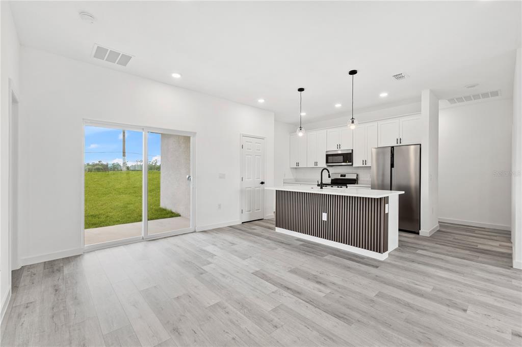 925 Desmoines Way Poinciana, FL 34759 - Photo 15 of 40 a kitchen with stainless steel appliances granite countertop a sink a refrigerator and a stove