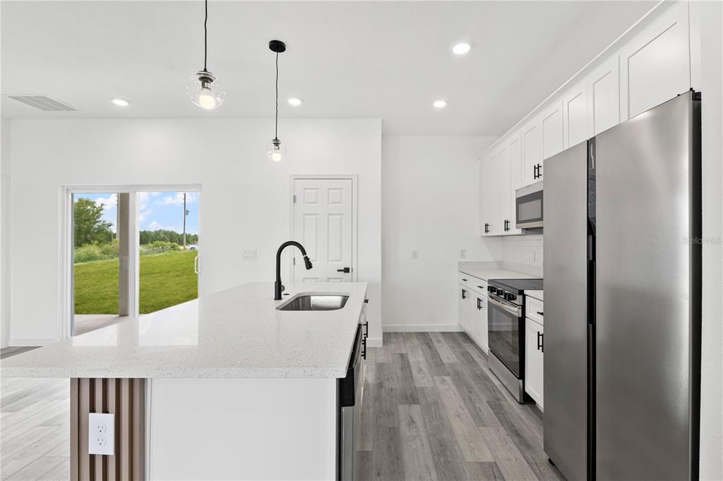 925 Desmoines Way Poinciana, FL 34759 - Photo 21 of 40 a kitchen with stainless steel appliances a refrigerator sink and stove