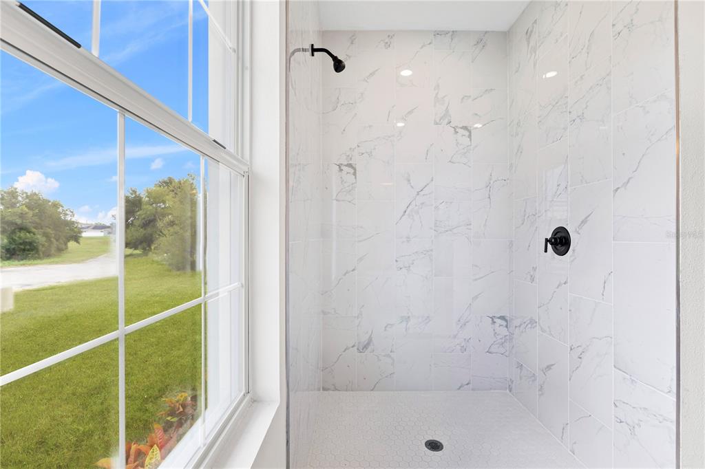 925 Desmoines Way Poinciana, FL 34759 - Photo 28 of 40 a bathroom with a glass shower door