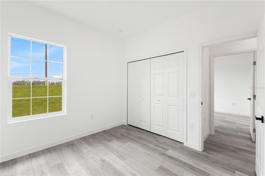 925 Desmoines Way Poinciana, FL 34759 - Photo 31 of 40 an empty room with a window and wooden floor