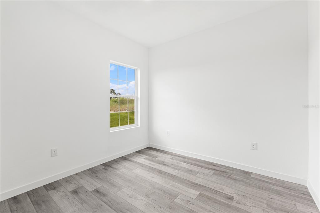 925 Desmoines Way Poinciana, FL 34759 - Photo 34 of 40 a view of an empty room with wooden floor and a window