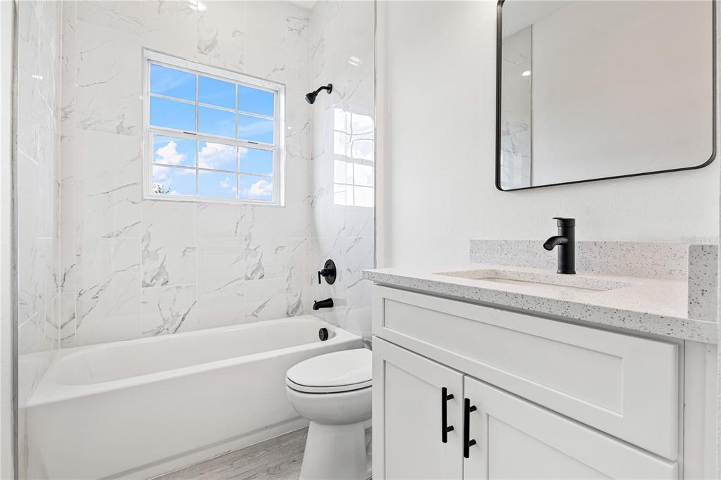 925 Desmoines Way Poinciana, FL 34759 - Photo 35 of 40 a bathroom with a toilet a sink a mirror and bathtub