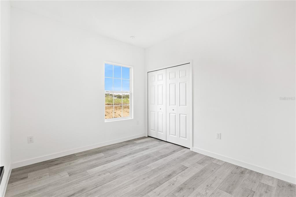 925 Desmoines Way Poinciana, FL 34759 - Photo 36 of 40 a view of an empty room with wooden floor and a window