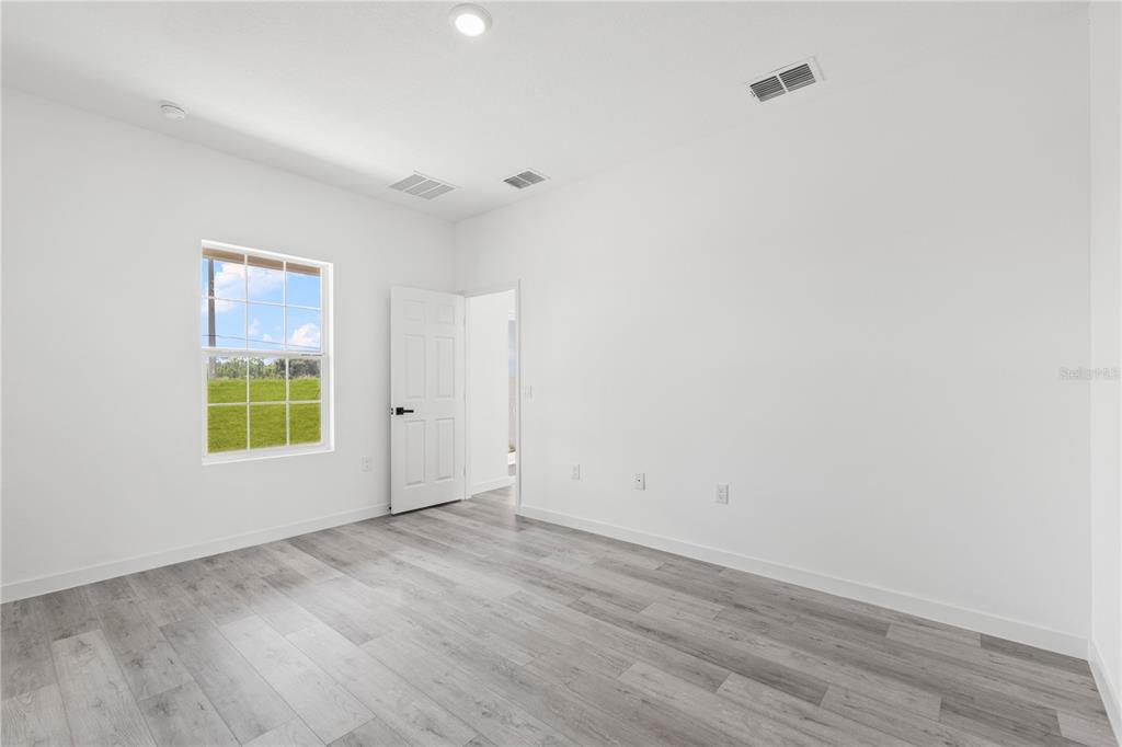 925 Desmoines Way Poinciana, FL 34759 - Photo 38 of 40 a view of an empty room with wooden floor and a window