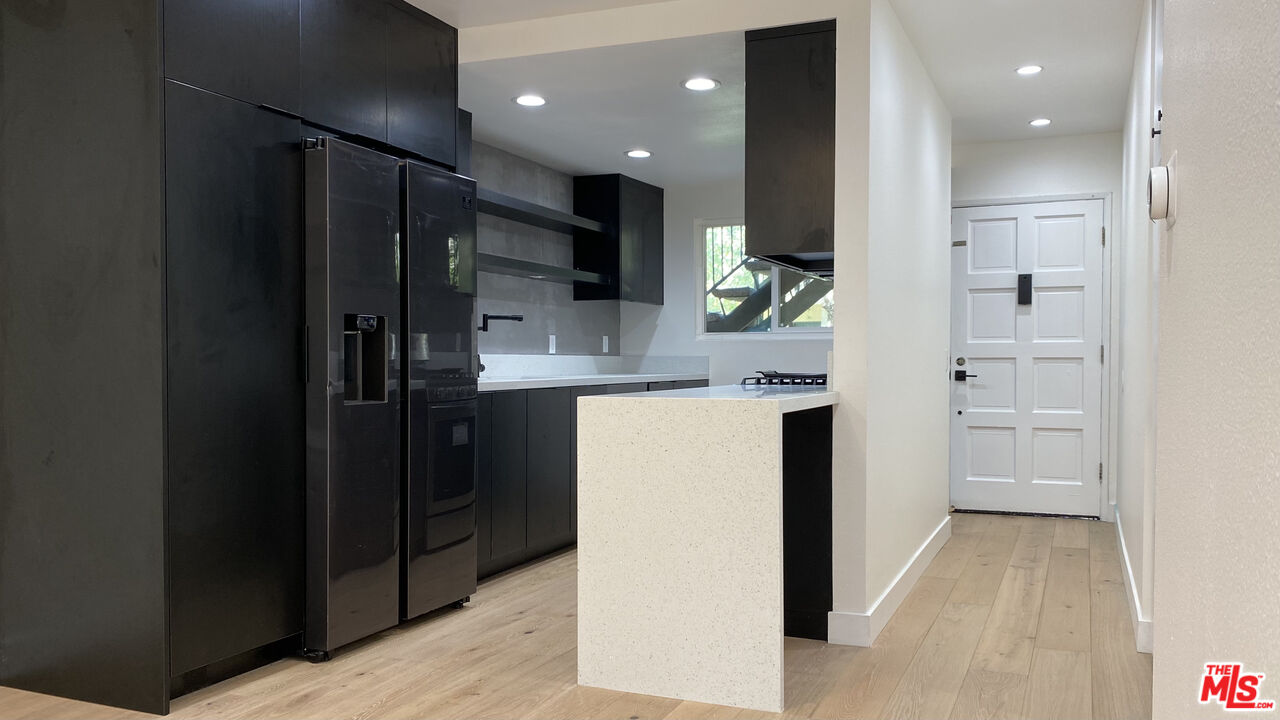 6474 Cavalleri Road Malibu, CA 90265 - Photo 11 of 24 a kitchen with kitchen island white cabinets and refrigerator