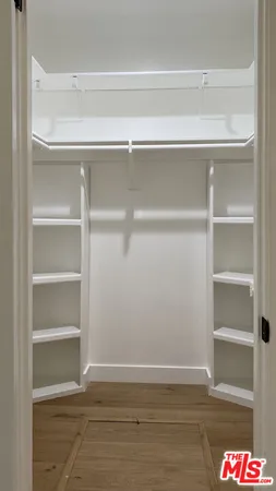 a view of walk in closet with empty racks