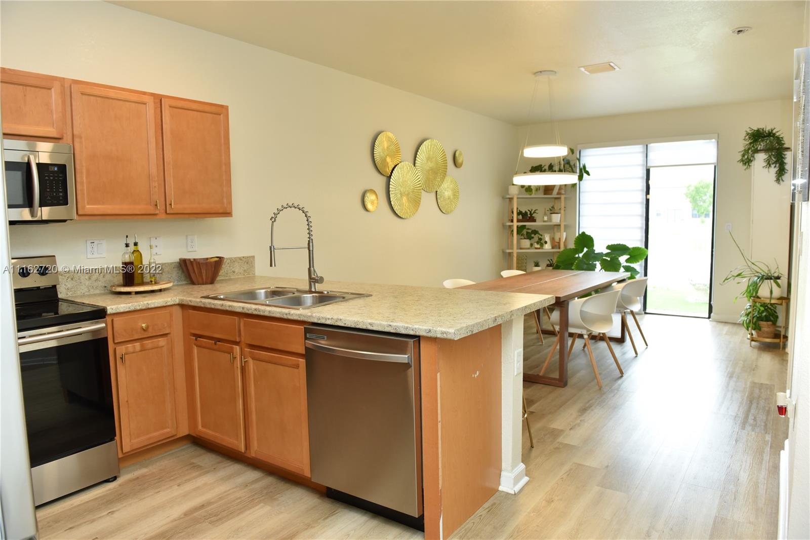 Hialeah Hialeah, FL 33018 - Photo 14 of 60 a kitchen with stainless steel appliances granite countertop a table chairs stove and sink