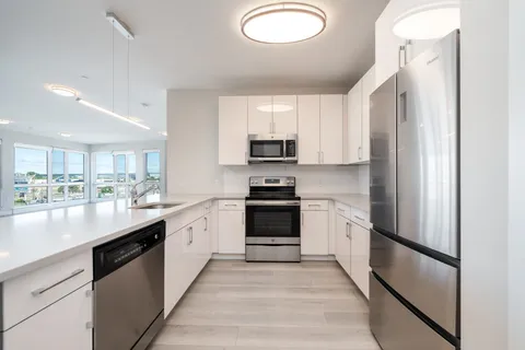 a kitchen with stainless steel appliances granite countertop a refrigerator a stove a sink and a microwave