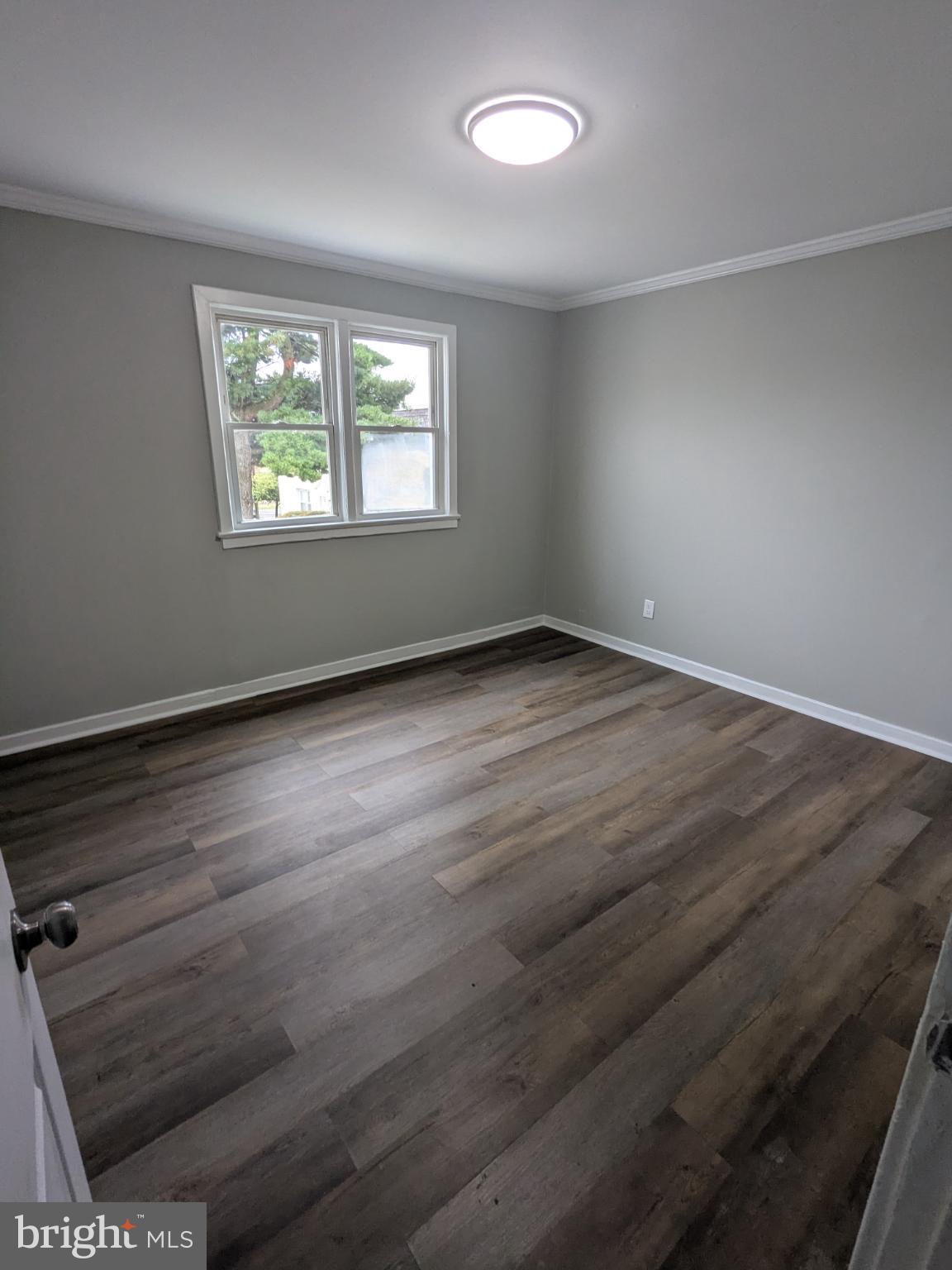 2834 Iverson Street, Unit 101 Temple Hills, MD 20748 - Photo 5 of 13 an empty room with wooden floor and windows