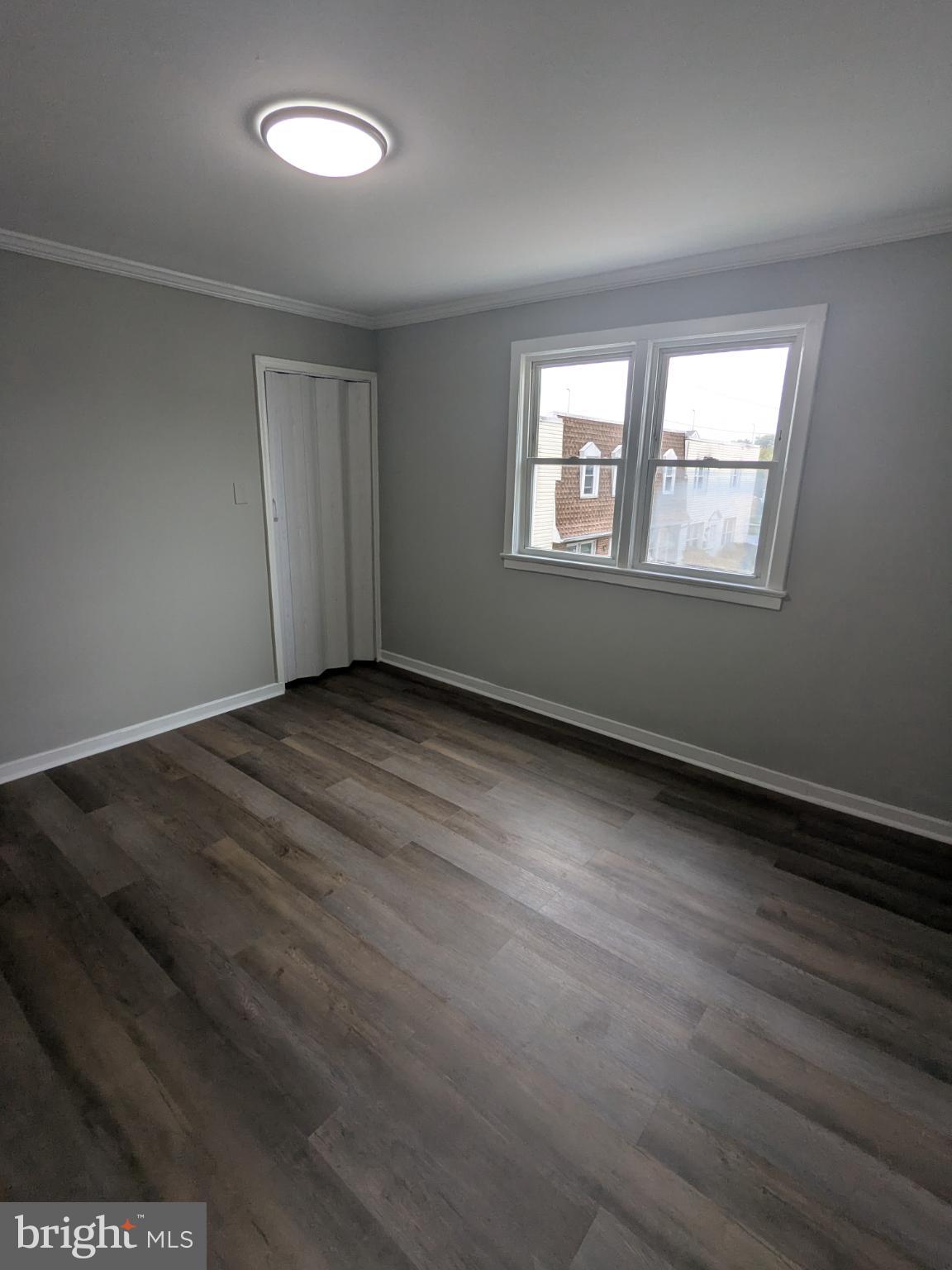 2834 Iverson Street, Unit 101 Temple Hills, MD 20748 - Photo 9 of 13 an empty room with wooden floor and windows