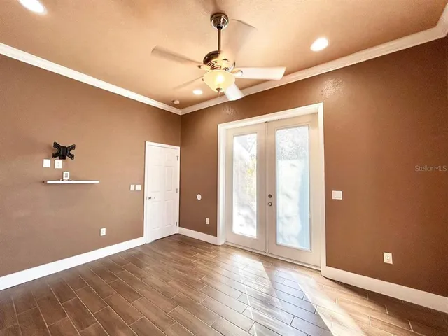 a view of an empty room with window and wooden floor