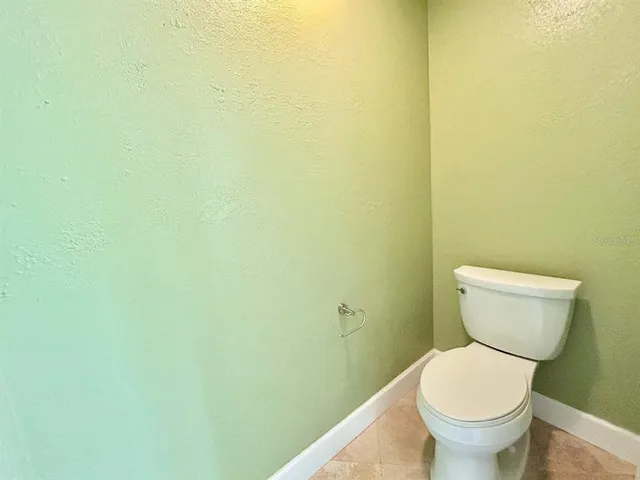 a white toilet sitting next to a white wall