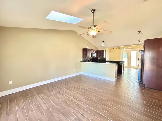 a view of a kitchen with wooden floor and an empty space