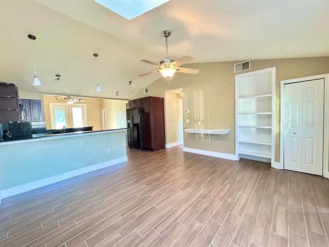 a view of an empty room with a window and wooden floor