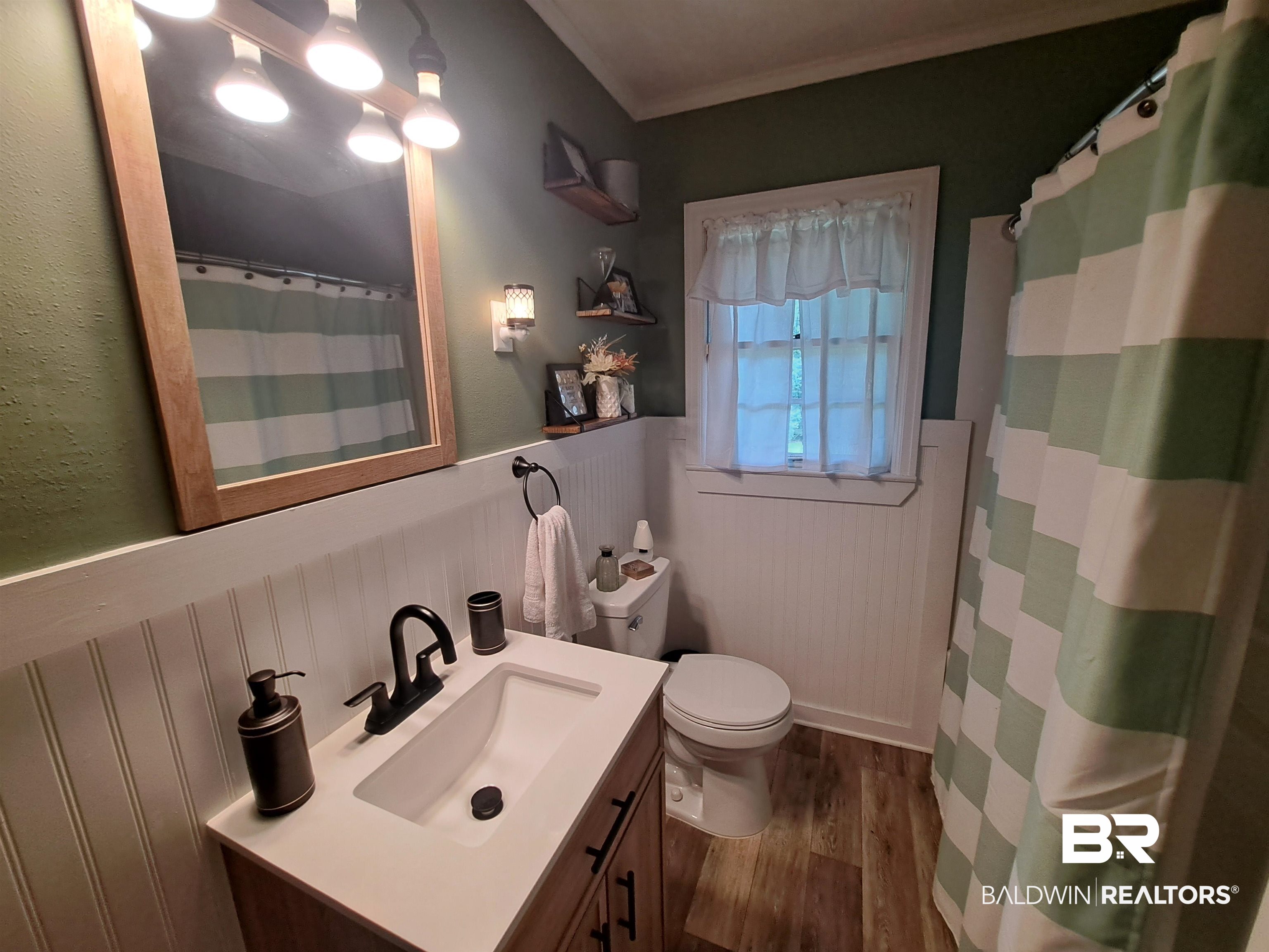 249 Newton Parkway Evergreen, AL 36401 - Photo 13 of 28 Bathroom featuring a wainscoted wall, a shower with curtain, dark wood-style flooring, and vanity