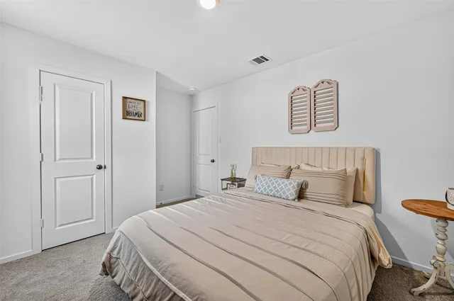 a bedroom with a bed next to a desk