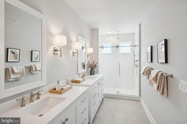 a bathroom with a double vanity sink mirror and shower