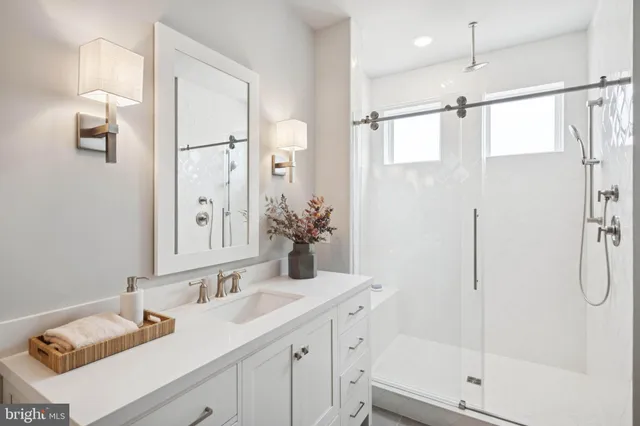 a bathroom with a granite countertop sink a shower and a mirror