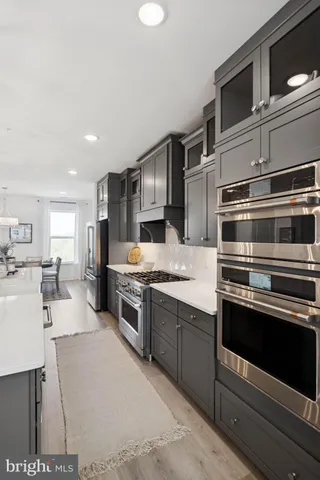 a kitchen with stainless steel appliances kitchen island granite countertop a stove a sink and a refrigerator